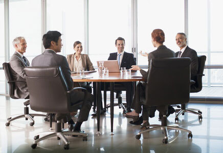 Business people sitting around a board room table